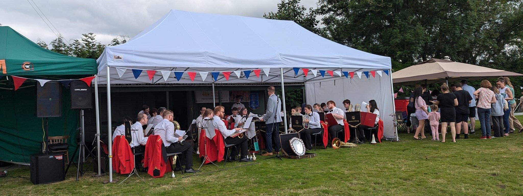 a full brass band inside a white pop up gazebo