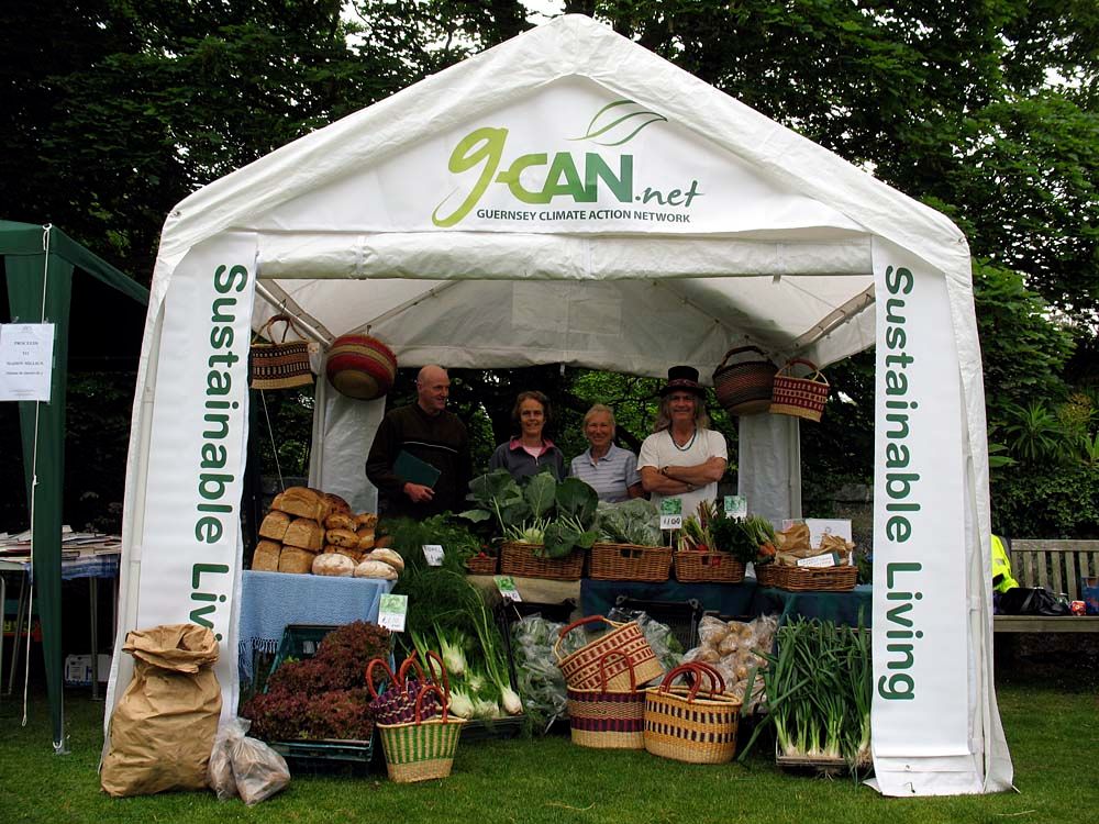 Trade stands and visitors at an outdoor farmers market