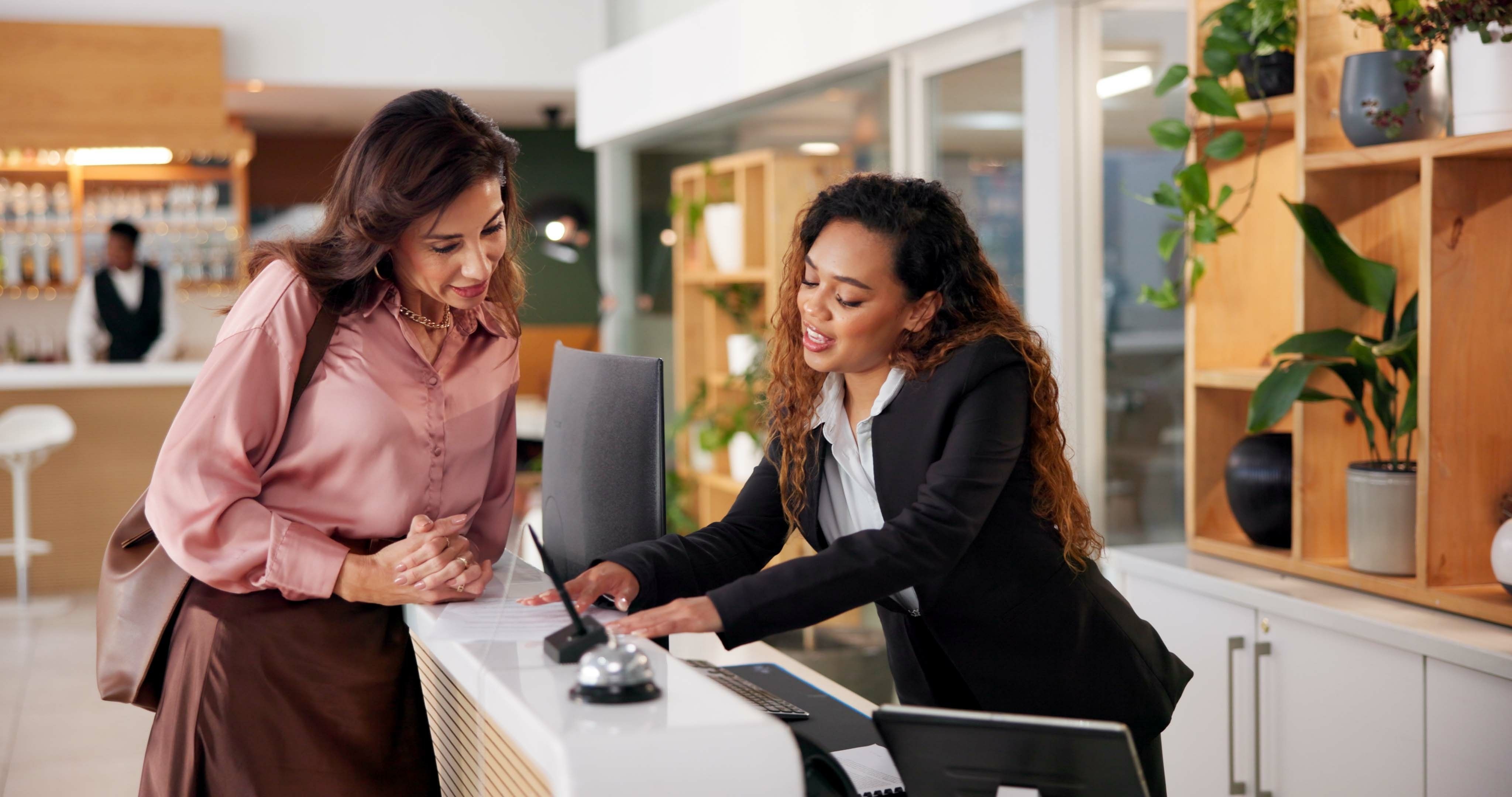 Hotel receptionist taking a booking at the front desk