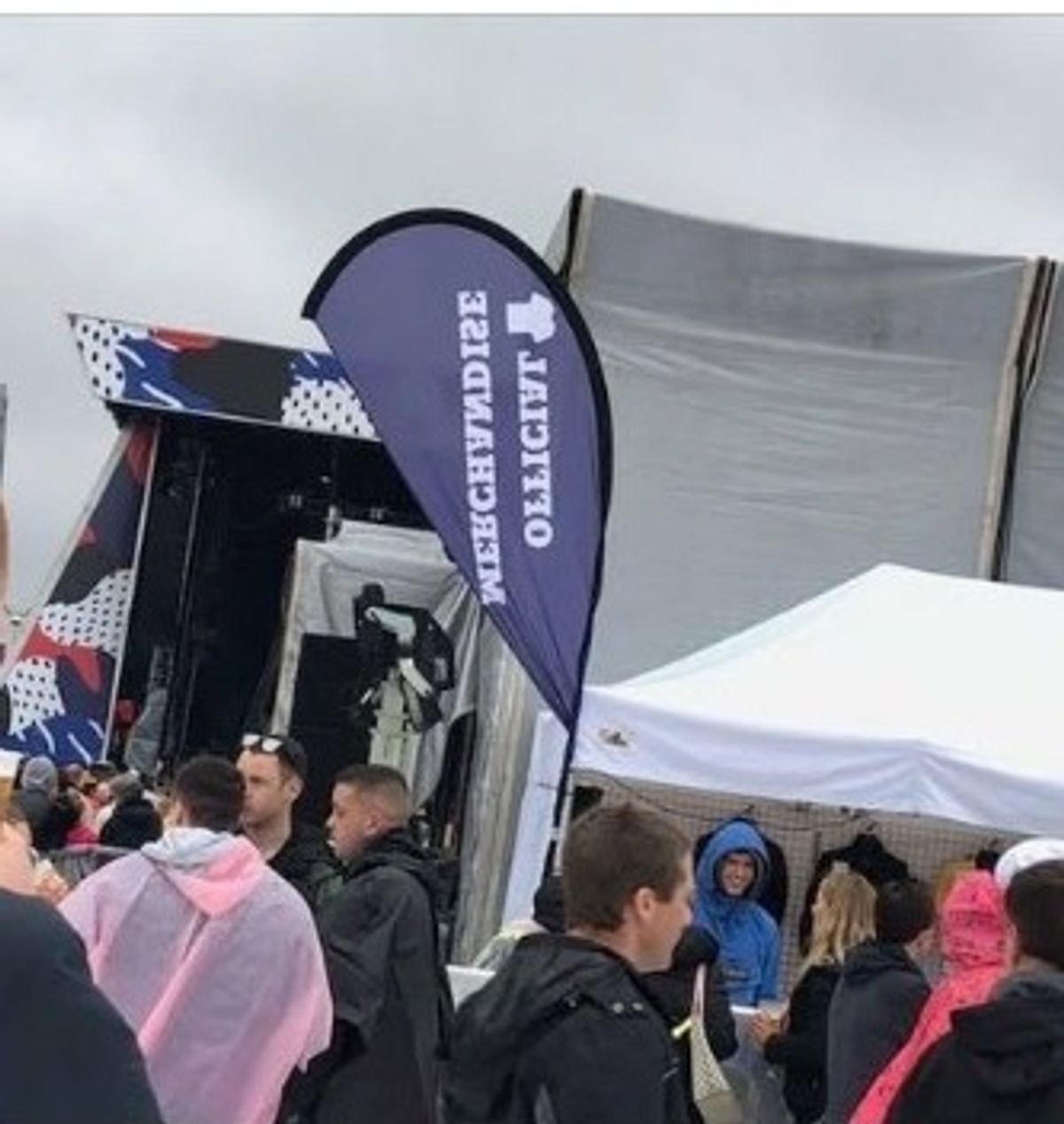 White Gala Tent gazebo beside the official merchandise flag at a Liam Gallagher concert in Belfast