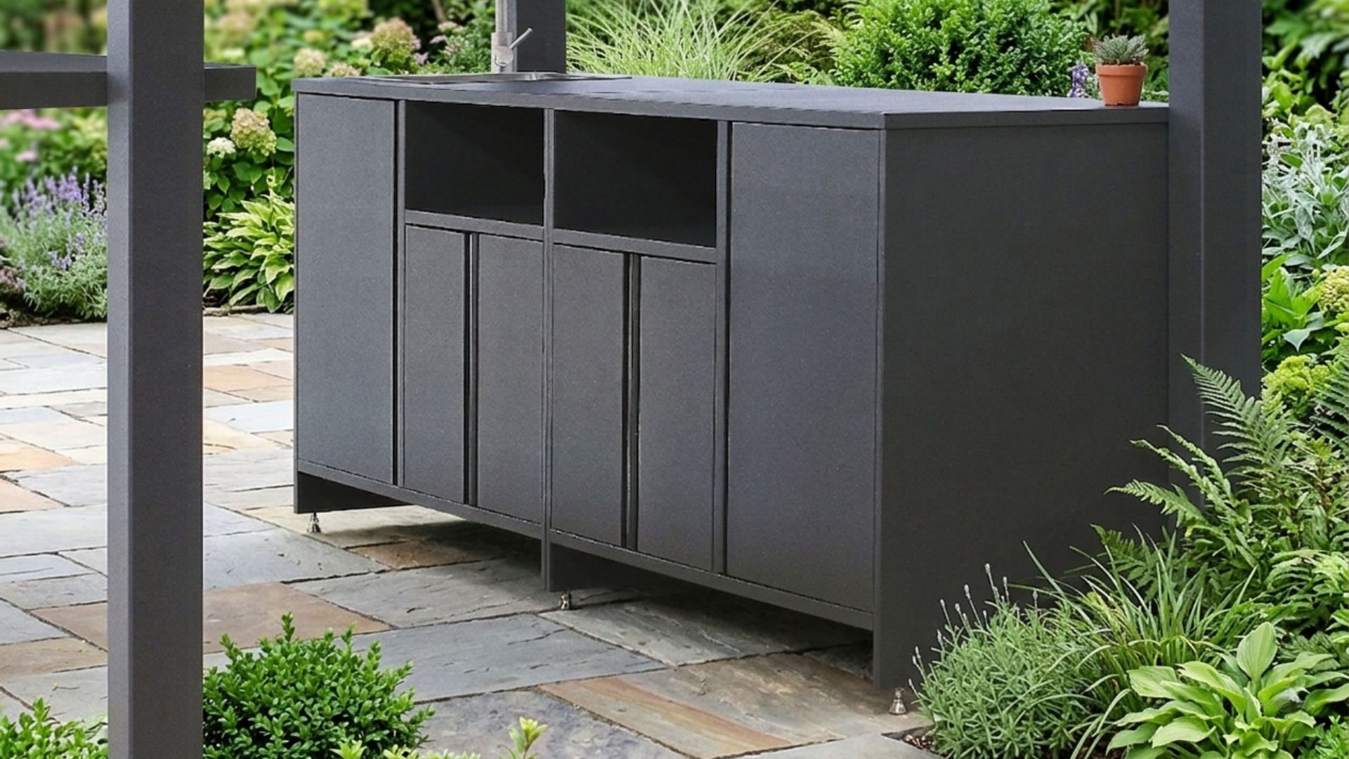 Rear view of the Lumina pergola bar showing anthracite storage cabinets on adjustable feet over garden paving
