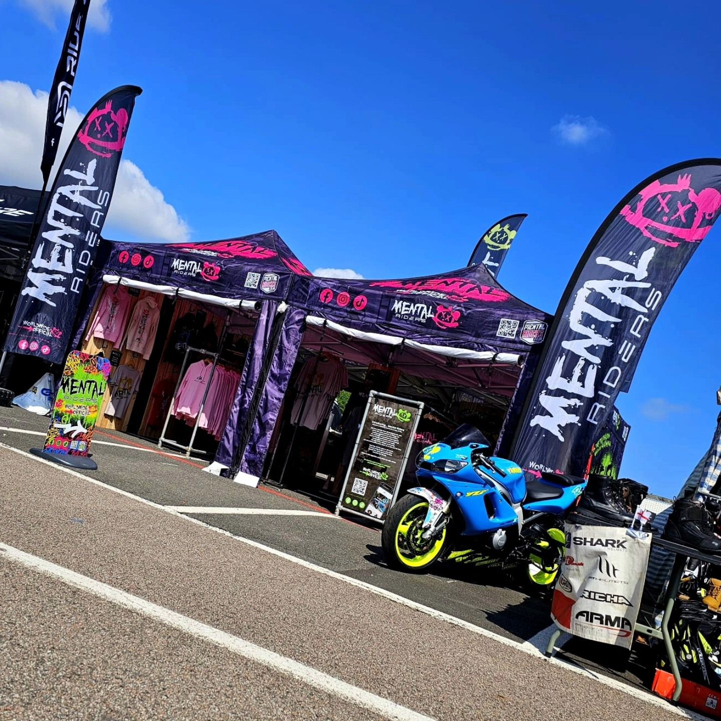 Motocross bike and pit gazebo set up at a muddy MX track