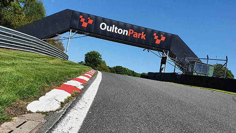 Race car through the parkland at Oulton Park