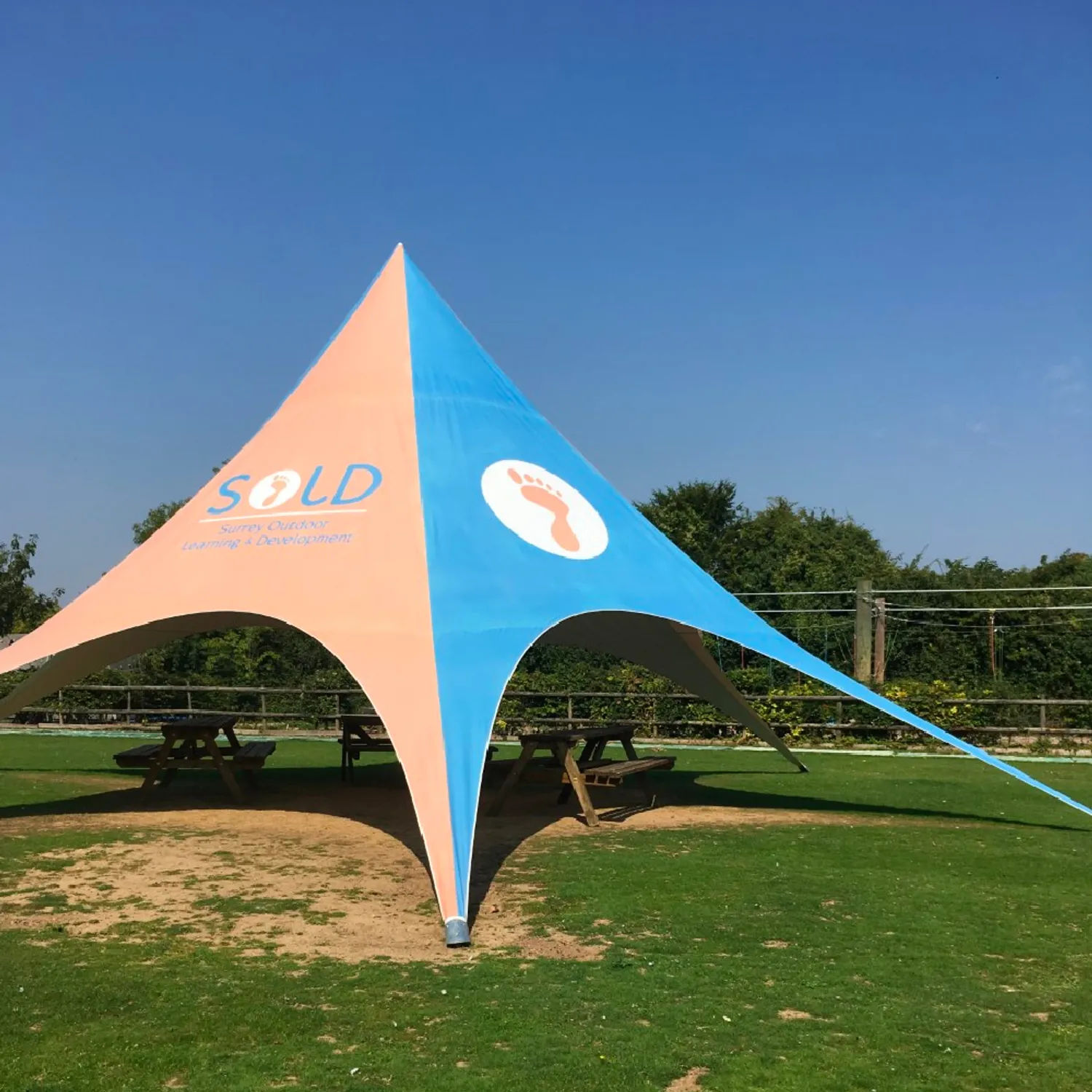 Branded star shade tent covers a picnic area