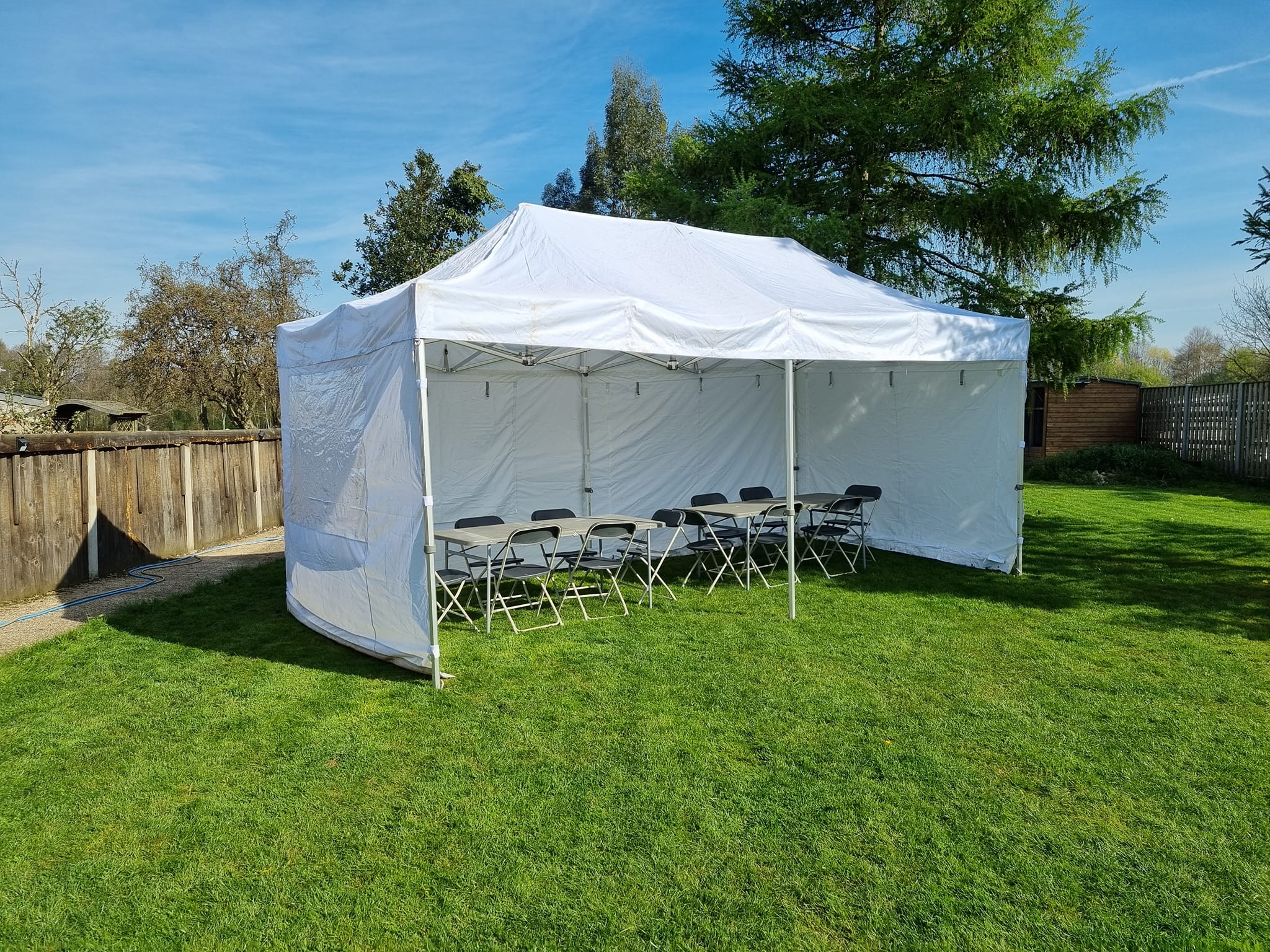 A white gazebo with sides in a garden